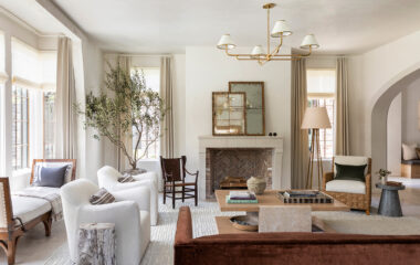 A living area with lighting, drapes and shades.