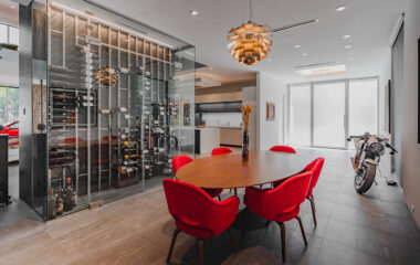 A modern museum home with wine rack and motorcycle.