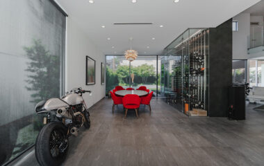 A modern museum gallery-style home with wine rack and motorcycle.